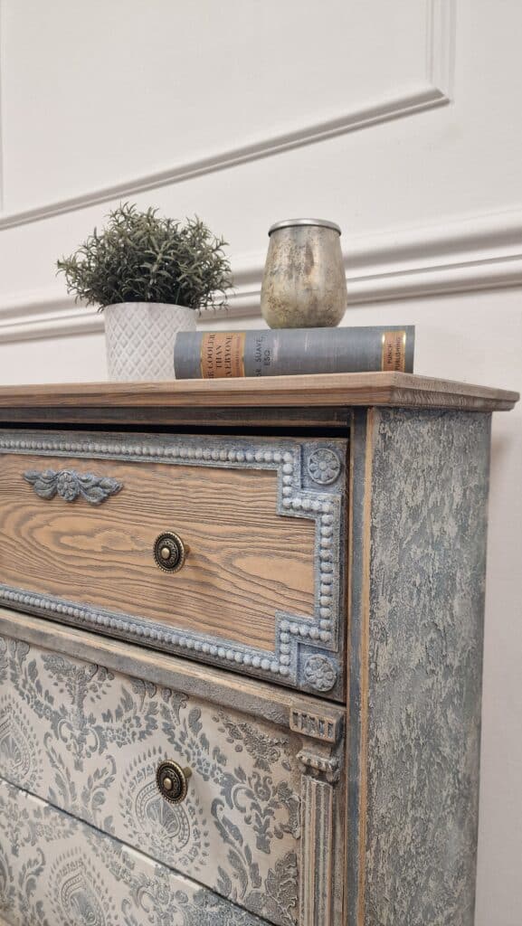 Widok na boczny panel i rzeźbioną nogę komody w stylu French Vintage, z efektem strukturalnym i przecieranym.